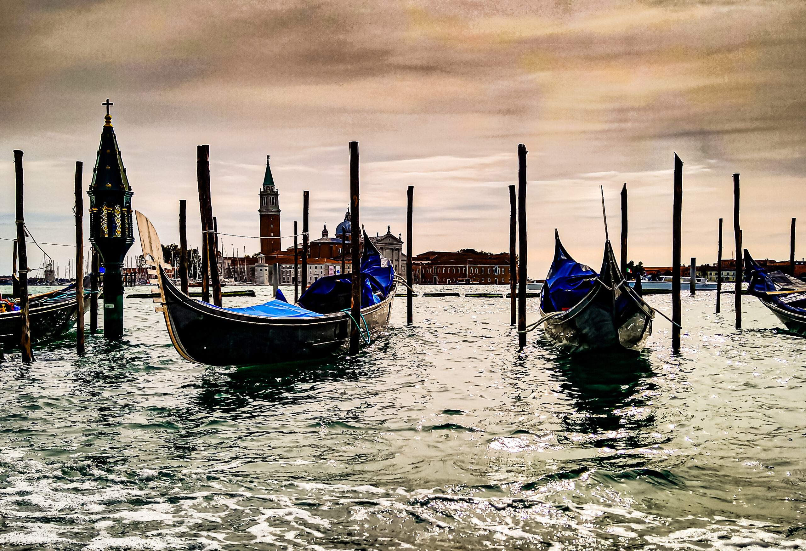 Gondolas moored at dawn with San Giorgio Maggiore in the background, Venice, Italy.