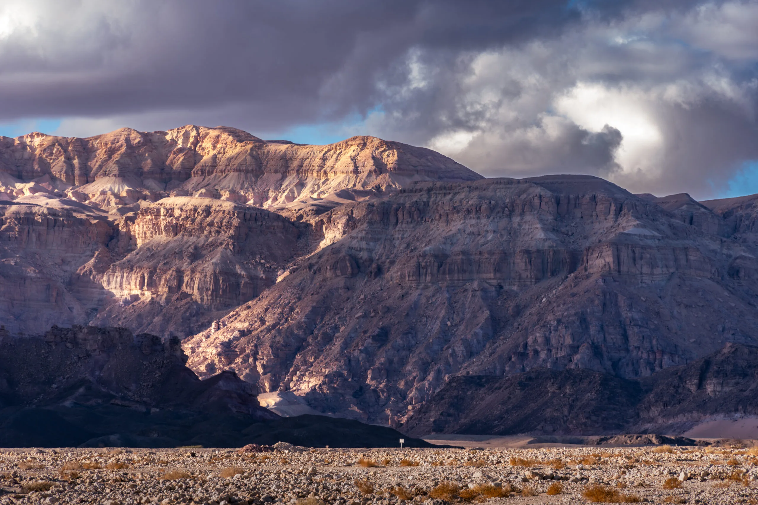 Sunlight breaking through storm clouds over the sandstone cliffs of Timna Park, Israel.
