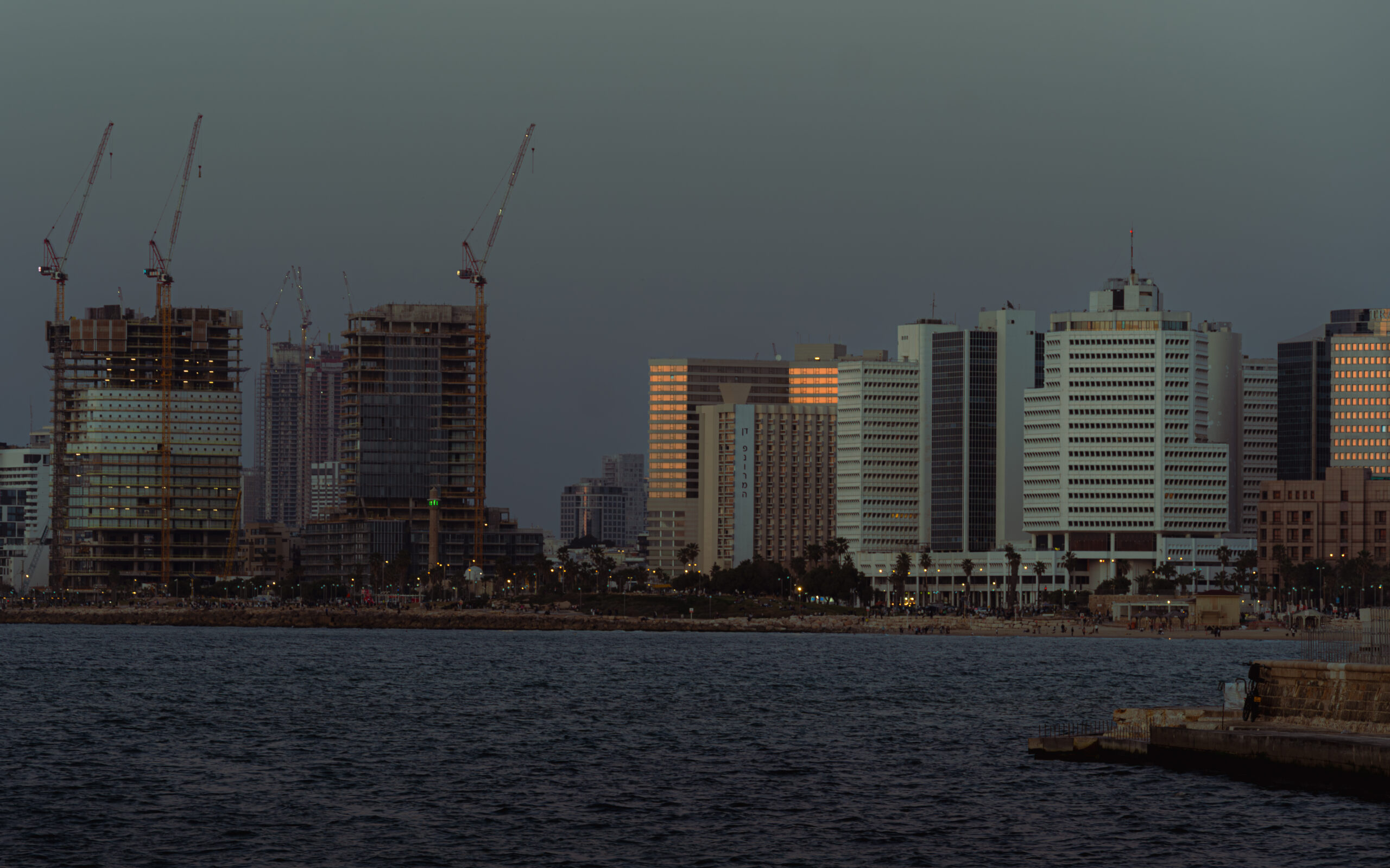 Blue hour view of the Tel Aviv skyline and Mediterranean coast after sunset.