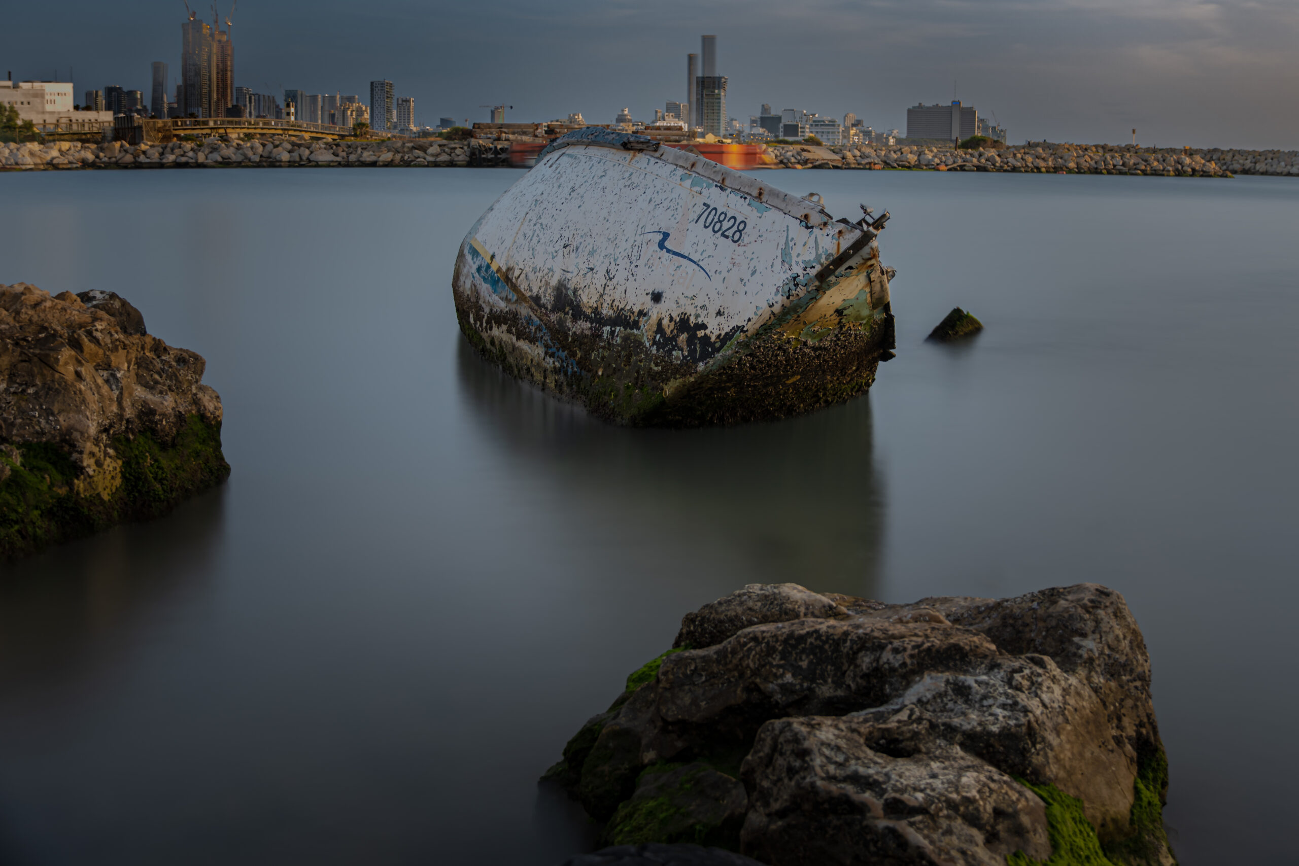 Abandoned boat resting at the mouth of the Yarkon River in Tel Aviv, Israel.
