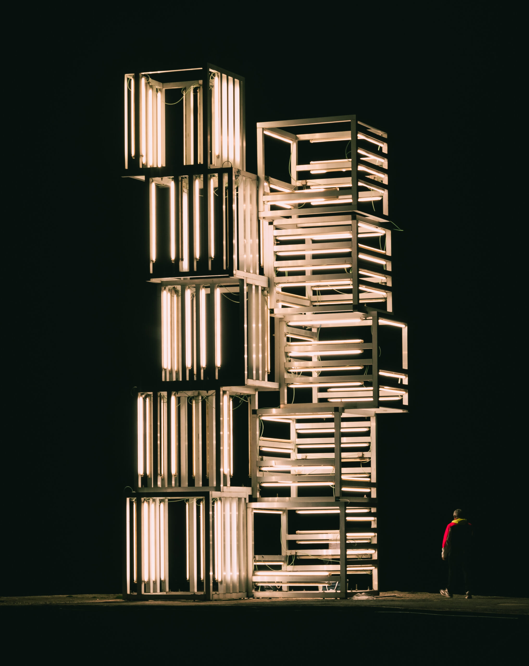 Illuminated modern sculpture at night in Lisbon, Portugal.