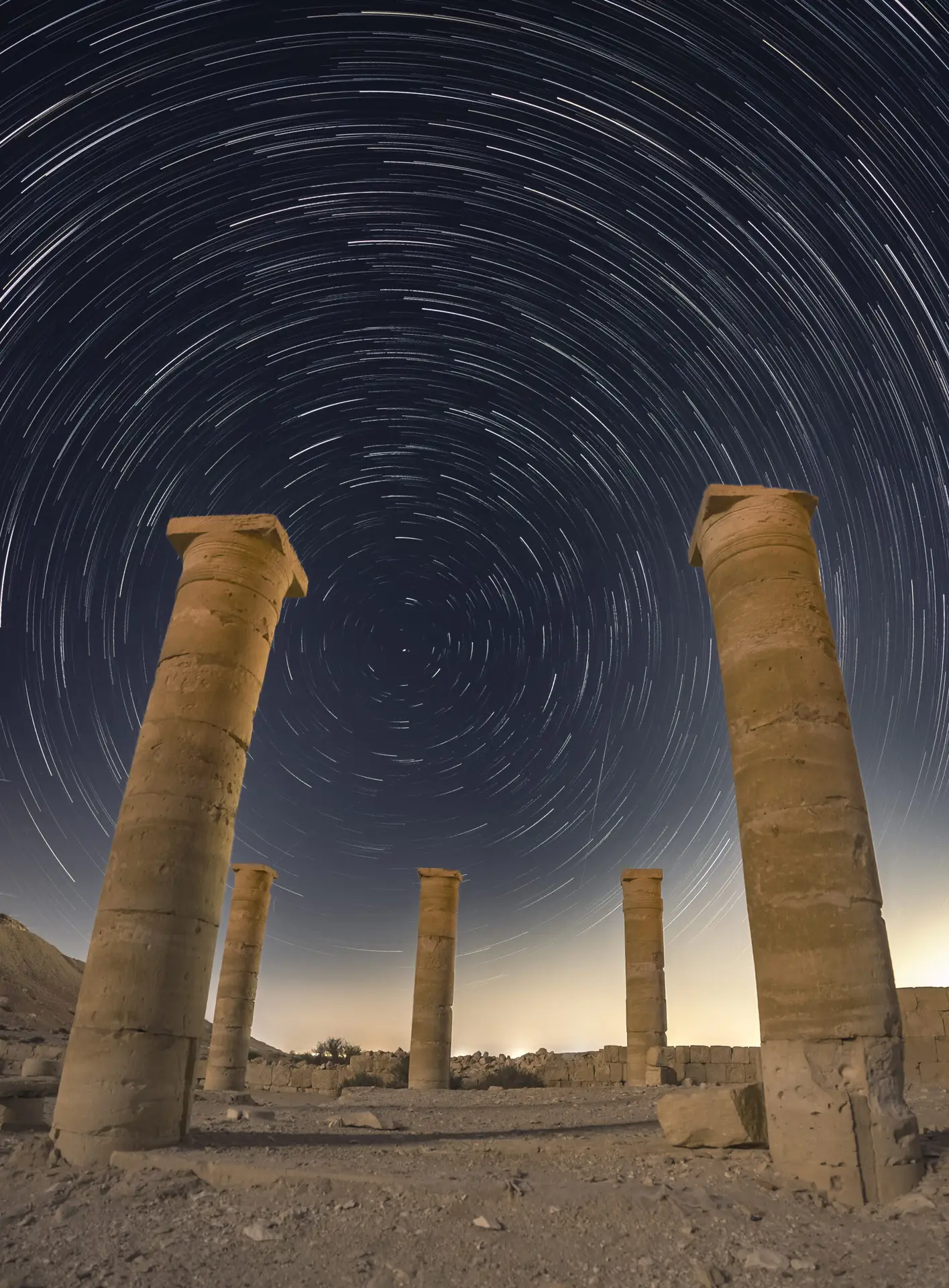 Circular star trails above the ancient stone columns of Nitzana in the Negev Desert, Israel.