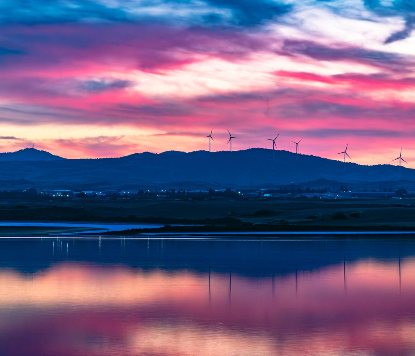Pink and purple sunset reflected in the still waters of Larnaca Salt Lake, Cyprus.